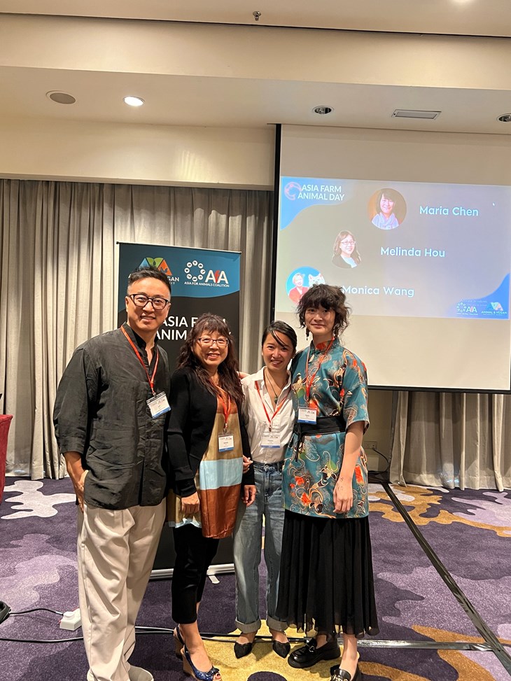 CIWF China Jeff Zhou poses with other speakers in front of the AFAD logo after speaking on animal welfare